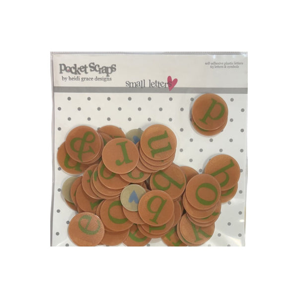 A package of 'Pocket Scaps' brand 'small letter' alphabet stickers. The clear plastic bag contains numerous round, tan-orange stickers printed with green lowercase letters, set against a white background with gray polka dots on the header card.