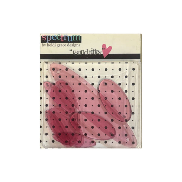 Spectrum by Heidi Grace Designs  oval embellishments in translucent pink, packaged in a clear plastic bag with a black and white polka dot backing card.