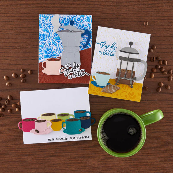 Three coffee-themed greeting cards on a wooden surface with coffee beans and a green mug.