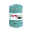 A skein of Hoooked Ribbon XL in a dusty teal color, wound on a cardboard spool with a white label.
