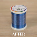Spool of blue thread with 'Magnifico' label on a wooden surface