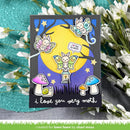 A handmade layered card featuring cute moth and butterfly fairy designs, set against a dark gray background with white flowers and a teal textured fabric backdrop. The card has a yellow moon, purple and blue stars, mushrooms, and the text 'i love you very moth'.