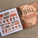 A printed sheet of vintage-style ticket and badge stickers placed next to a matching decorative card or book cover on a textured beige fabric background. The design uses distressed brown, tan, orange, and muted red tones with text such as 'Hall of Mirrors,' 'Admit One,' 'Chance Admission,' and 'Fortune Fold.