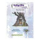 IndigeBlu 'Fairy Business' rubber stamp card featuring an illustration of a stone cottage with a tree trunk for a roof, a small flower, and decorative text on a distressed light blue background.