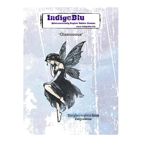 IndigeBlu 'Glamorous' fairy rubber stamp packaging, featuring a black ink sketch of a fairy with dark wings on a distressed light blue and white background.
