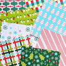 A flat-lay arrangement of multiple Christmas-themed patterned papers or wrapping paper designs, including plaid, stripes, snowflakes, stars, candy canes, and tree motifs in green, red, white, blue, and yellow.