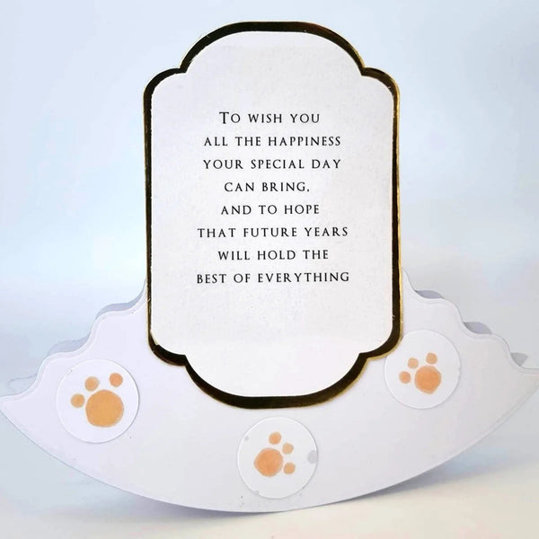 A white pet memorial plaque with a scalloped base and a central label containing a memorial quote, decorated with three orange paw print stickers.