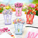 Colorful rain boots with floral arrangements on a wooden surface.