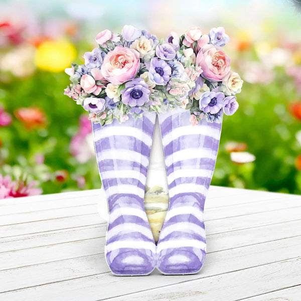 Purple and white striped socks with floral decorations on a wooden surface.