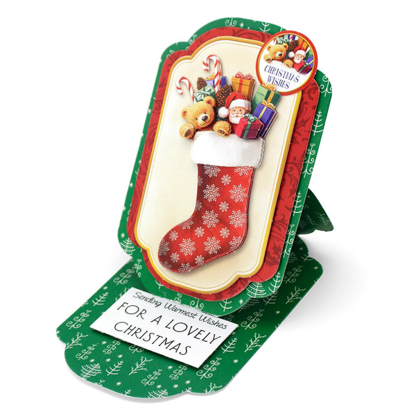 A Christmas-themed stand-up greeting card featuring a red stocking filled with teddy bears, candy canes, gifts, and Santa Claus, with green patterned cardstock and a white message reading 'Sending Warmest Wishes FOR A LOVELY CHRISTMAS'.