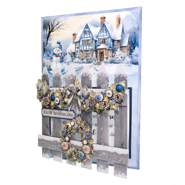 Christmas card with snowy village scene, snowman, and decorative elements.