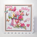 A square handmade birthday card for 'Mum' featuring a colorful floral bouquet in a pink checkered vase, butterflies, hearts, and the words 'Happy Birthday Mum' in pink script, displayed on a clean white background.