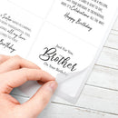 Hand holding a birthday card with personalized text on a wooden surface