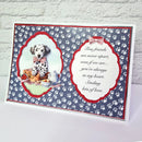 A handmade greeting card featuring a Dalmatian illustration and a paw-print pattern, displayed on a white surface against a white brick wall. The left side shows a Dalmatian with a red bow tie next to a picnic scene, while the right side has a white scalloped box with the message: 'True friends are never apart, even if we are.