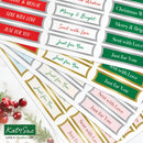 A set of decorative holiday gift tags with festive text such as 'Merry & Bright,' 'Just for You,' and 'Sent with Love' in red, green, pink, gold, and white designs. The tags are arranged on a light background with a small holiday berry illustration in the lower left.