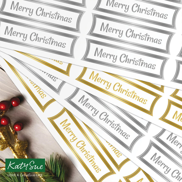 Sheet of 'Merry Christmas' labels with gold and silver text, featuring Katy Sue branding.