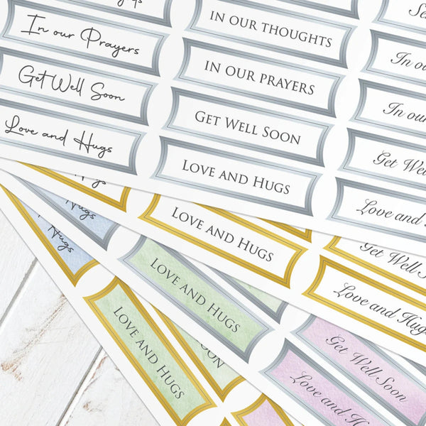 Collection of printed cards with messages like 'In our prayers' and 'Get Well Soon' on a wooden surface.
