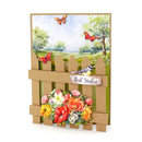 Greeting card with floral arrangement, birds, and butterflies on a cardboard fence design.