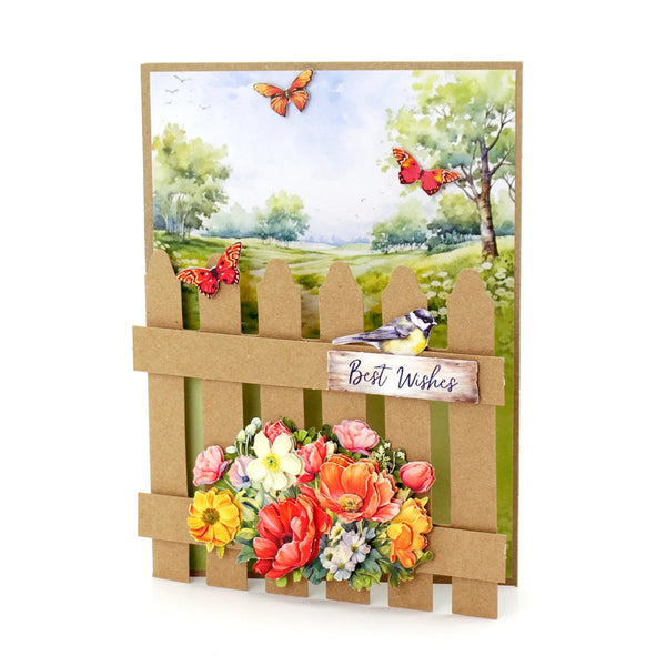 Greeting card with floral arrangement, birds, and butterflies on a cardboard fence design.