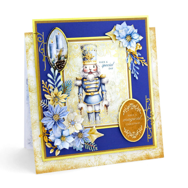 A handmade Christmas nutcracker card featuring a blue and gold nutcracker figure, blue and gold poinsettia flowers, and elegant gold foil details on a dark blue and gold layered card base.