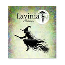 A square product card for Lavinia Stamps featuring a black silhouette of a witch riding a broomstick in front of a full moon and mushroom graphic. The card has a mottled pastel background with green, yellow, blue, and purple tones, and includes repeated website watermarks.