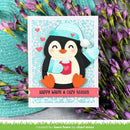 A handmade layered card featuring a cute penguin wearing a light blue plaid beanie and matching mittens, holding a pink mug with a heart. The card is styled with purple flowers and a textured teal fabric background.
