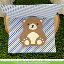 A handmade paper pop-up gift box featuring a cute brown bear with a cream belly and black nose, set against a blue and white striped background. The box is displayed open on a green grass-like surface.