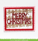 A handmade Christmas card featuring the words 'MERRY CHRISTMAS' in glittery red letters, surrounded by small gingerbread men figures. The card has a red border and a pink patterned backing, shown against a white background with a green grass graphic at the bottom.