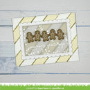 A handmade holiday greeting card with five brown gingerbread men, white scalloped borders, and the words 'season's greetings' on a light wood background.