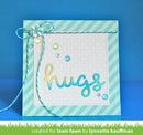 A handmade greeting card with a mint green and white striped border, a white polka-dot center panel, and the word 'hugs' in metallic gold and blue gradient lettering. A mint green and white twine bow with a pearl accent sits on the upper left.