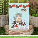 A handmade autumn-themed greeting card featuring a cute gray cat with an orange patterned sweater, acorns, and the words 'thanks' and 'you're the cat's meow!' displayed on a rustic wood slice stand, with cacti in the background.