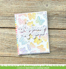 Card with colorful butterfly designs and 'thinking of you' text on a wooden surface