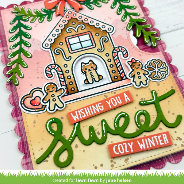A handmade winter-themed greeting card or craft plaque featuring a gingerbread house with a dog window, candy canes, gingerbread figures, green leafy accents, and raised text reading “Wishing You a Sweet Cozy Winter.”.