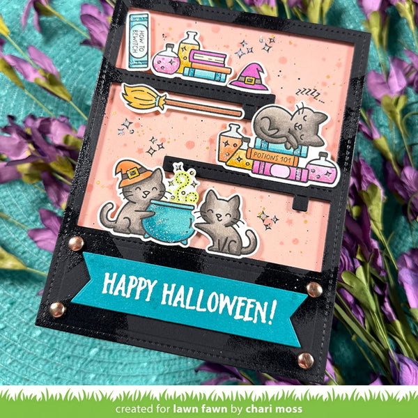A handmade Halloween greeting card with a black faux-leather border, featuring cute cartoon cats, a cauldron, potion bottles, a broom, and a gray elephant on a pink background. A teal banner at the bottom reads 'HAPPY HALLOWEEN!'.