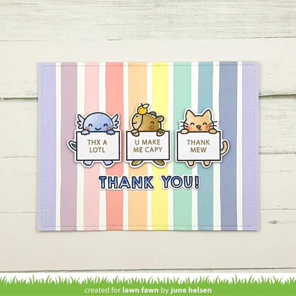 A handmade thank you card with pastel vertical stripes in lavender, pink, orange, yellow, green, blue, and purple. Three cartoon animals peek from behind the signs reading 'THX A LOTL', 'U MAKE ME CAPY', and 'THANK MEW', with 'THANK YOU!' in blue text below.