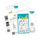 A Lawn Fawn stamp set displayed on a white background, including a clear stamp sheet with unicorn and rainbow designs, instruction cards, a roll of washi tape, and a small sticker. The packaging features a teal and green color scheme with white text.