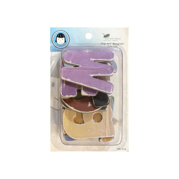A package of Art Department Design Shop wooden monogram letters, featuring a large purple 'M' and other colorful letters inside a clear blister pack with a blue header card.