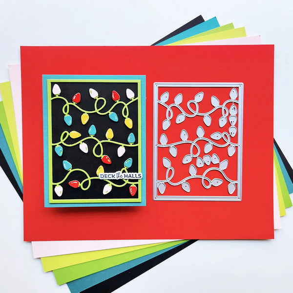 A handmade holiday card layout on a bright red cardstock base, featuring a black square panel with colorful Christmas string lights and a silver metal die-cut frame showing matching leaf and light motifs. Stamped text reads 'Deck of Halls.