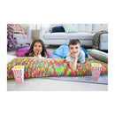 Two children lying on a colorful blanket with popcorn boxes in a living room.