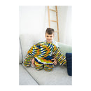 Child holding a colorful knitted toy on a couch with a ladder in the background