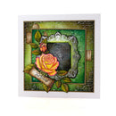 A square handmade greeting card featuring a vintage-style floral design with a large yellow and pink rose, smaller rosebud, green leaves, an ornate silver frame, and a banner reading 'Just in Time'. The card has a layered collage design with a green background, cursive script, and textured details, presented on a clean white background.
