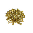 A pile of small metallic gold push pins on a plain white background.