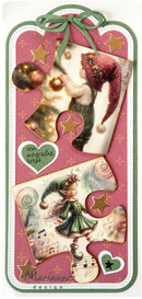 A decorative Christmas-themed paper tag or bookmark with layered vintage illustrations of elves, gold stars, a green ribbon bow at the top, and the text 'Marianne design' at the bottom on a pink background.