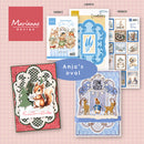 A collage of craft kit and card designs from Marianne Design, including multiple paper templates, sticker sheets, and finished holiday-themed cards with animals and winter motifs on a pink grid background.