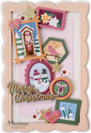A festive handmade Christmas collage card or scrapbook page featuring multiple layered frames, snowman and nutcracker illustrations, a pink bird, gold glitter stars, hearts, and the words 'Merry Christmas' on a pale pink background. The brand name 'Marianne design' appears in the lower left corner.