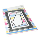 A packaged die-cut craft sheet from Marianna Design's Crafter's Block line, featuring a black scalloped frame around a white geometric shape, set against a colorful striped backing card.