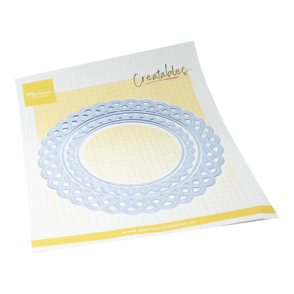 A light blue scalloped oval die-cut craft template on a white and yellow branded backing card, photographed on a clean white background.