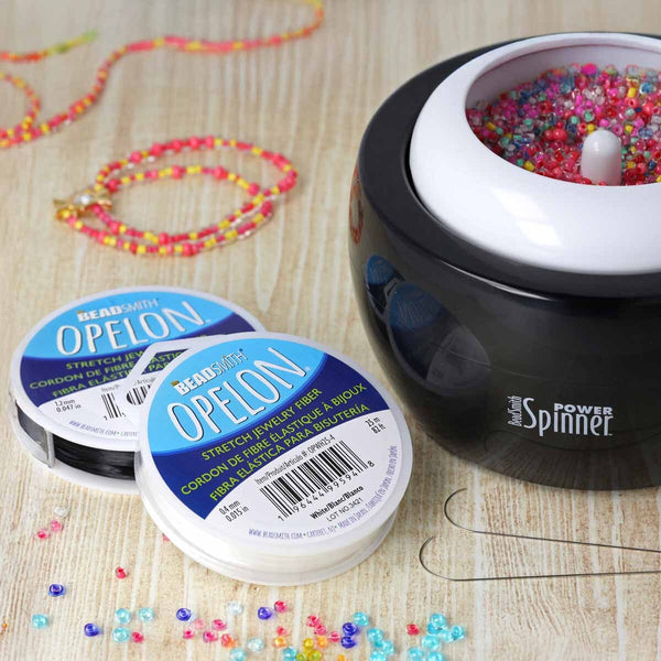 Opelon stretch jewelry fiber with Power Spinner and beaded bracelet on a wooden surface