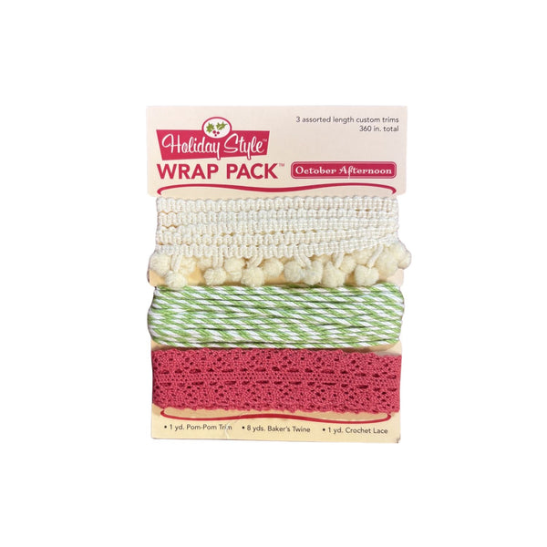 Holiday Style Wrap Pack containing three assorted length custom trims: a cream pom-pom trim, a green and white striped baker's twine, and a dusty pink crochet lace trim, shown in its retail packaging.