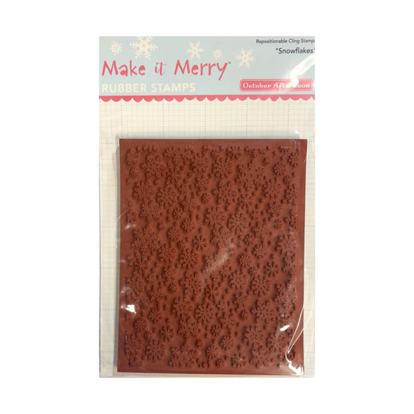 A packaged rubber stamp featuring an embossed snowflake pattern, labeled 'Make it Merry Rubber Stamps' and 'October Afternoon', shown in clear plastic packaging against a white background.